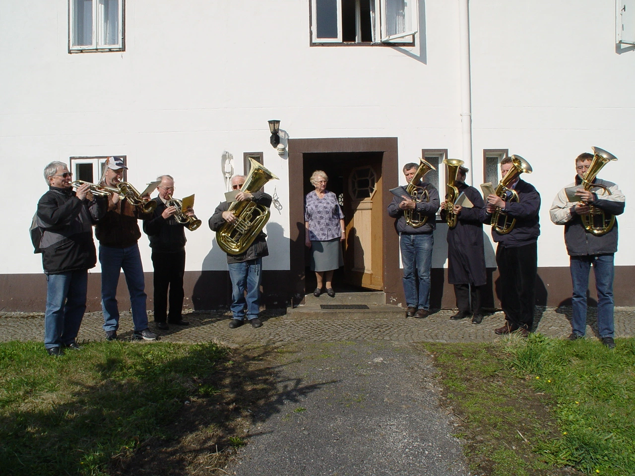 Die Bläsergruppe spielt vor einem Haus, 2003